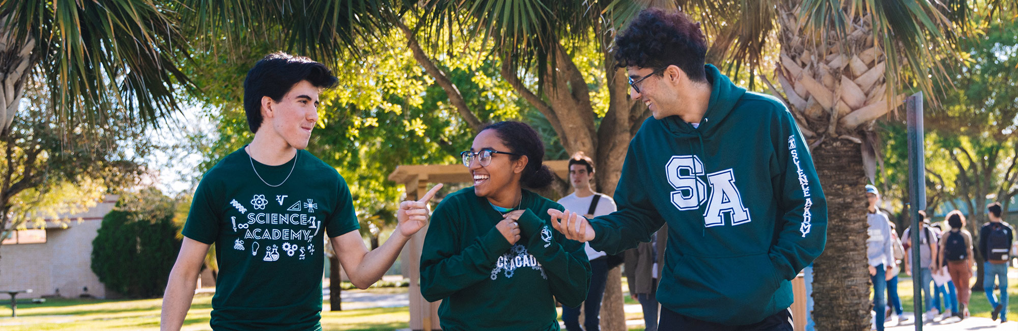  studenci spacerują po uniwersyteckim parku i rozmawiają ze sobą