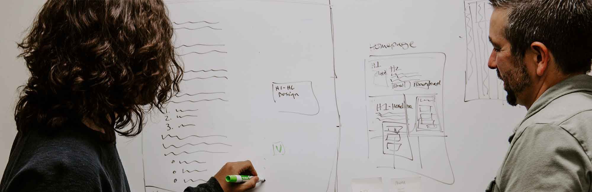 kobieta z mężczyzną rysuje na tablicy